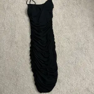 En svart klänning till knäna men vill man ha den kortare går det lätt att dra upp den utan att det ser konstigt ut, använd 1 gång 