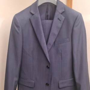 Kostymset från Bläck (blå) - Storlek kavaj: 46 tailored fit  Storlek byxor: 146 50% ull, 50% polyester 