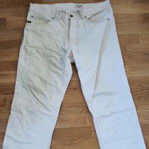 Tiger of Sweden Jeans i beige/krämvit färg - 34 W 30 L Loose/Relaxed passform Rätt så bra skick. Lite missfärgningar vid remmarna där man har bältet men inget synligt med bälte på.  Snygg och skön färg under sommaren!