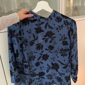 Blommig blus - Hör av er vid fler frågor!