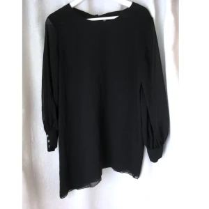 Svart tunika miniklänning chiffong stl. XS chiffong asymmetrisk långärmad - En svart tunika/miniklänning i chiffong. Silverfärgade tryckknappar i ärmsluten, långt knytband i nacken och snedskuren nederdel. Mått får ej plats - fråga gärna!