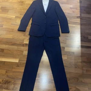 Mörkblå kostym 50 lång - Mycket fin mörkblå kostym inklusive skjorta från Dressman. Kavaj 50 lång, byxor 32x32, skjorta 41/42 L extra slim fit. Köpt till avslutningen förra året. Använd 2 ggr nu urvuxen. Pris: 1000 kr för hela kitet, nypris 2500kr