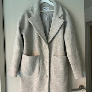 Kappa i ull - Lång kappa i ull från NA-KD, använd 5 gånger. I storlek 38. En grå, beige färg 