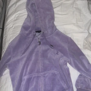 Syrenlilla Juciy Couture tröja  - Den är i bra skick, den är använd fåtal gånger och så har det ramlat av en silver sak på en utav snörena💕