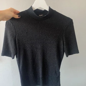 Glittrig fest topp - Snygg glittrig fest topp från bik bok. Älskar denna den är så skön och snygg! Har en bra passform som passar de flesta storlekarna typ xs-m. Skriv flr fler bilder!! Eller frågor!