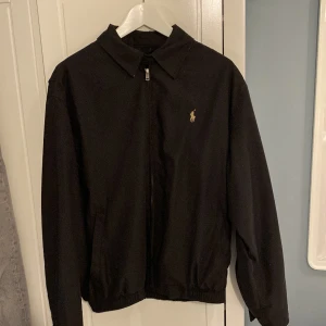 Polo Ralph lauren windbreaker - Hej, säljer denna assnygga raffe jacka i modellen BI-Swing Winndbreaker RL Black. Jackan är i gott skick utom en liten defekt längst ned på ärmen som knappast syns(be om bild). Jackan är köpt för runt 2400kr hos care of carl😊.