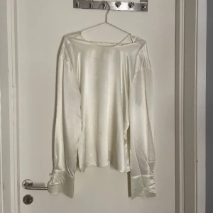 Fin, glansig blus - En super fin blus som är perfekt för finare tillfällen. Säljer för att det är större (L) och passar därför inte. Har bara använt en gång men ena knappen är av på vänster sida. Säljer därför gör bara 150 kr