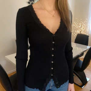 Svart långärmad spets tröja - Svart långärmad spets tröja med knappar.