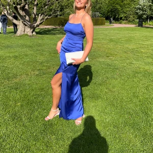 Blå balklänning  - En jättefin blå balklänning  från bubbelroom. Knytdetalj i ryggen, reglerbara axelband och dold ryggdragkedja. Endast använd 1 kväll på min skolbal. Är i super fint skick. Klänningen är i strl 42, bystvidd 102cm, midjevidd 86, stussvidd 110cm. 