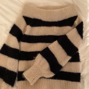 Randig stickad tröja - En stickad tröja som är offshoulder och randig, svart och beige. Aldrig använt, passar både S och M skulle jag nog säga.