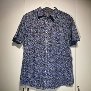 SCW Kortärmad skjorta  - Hej, säljer en blå blommigt mönstrad kortärmad skjorta från SCW Made For You. Storlek L men liten passform så snarare M. Nypris 600kr. Skönt material, bekväm passform. Pris kan diskuteras. Hör av dig vid frågor! 