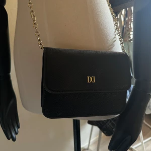 Svart DonDonna väska - En svart liten DonDonna väska✨ använd fåtal gånger🫶 Skriv till mig om fler bilder önskas🥰