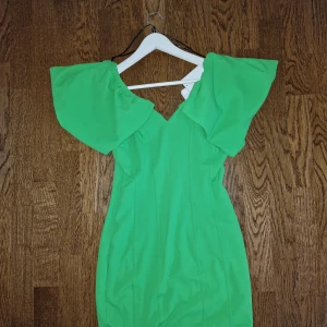 Limegrön Klänning - Säljer denna oanvända limegröna klänning från H&M. På prislappen står det att den är köpt för 499:- men jag kan släppa den för 449:-