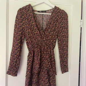 Röd/orange Zaraklänning  - Röd/orange Zaraklänning med små blommor på i olika färger💗