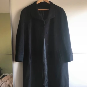 Lång svart kappa - Yllejacka, väldigt tjock i tyget, varm!!  Bra skick!