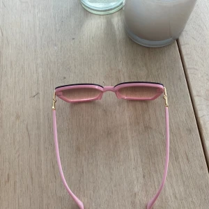 Ett par rosa röda solglasögon  - Ett par solglasögon med guld och diamanter ditaljer på. Är från Turkiet (det är gjorda där också)dröjer dom för 50kr eller om ni vill lägga ett bud så går det bra 