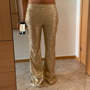 Guldiga glitterbyxor  - Snygga  guldiga, glitter och paljettbyxor. Väldigt fina och sitter bra. De är stretchiga i midjan och kan nog passa mellan 36-40. Lägg gärna prisförslag! 🥰🥰
