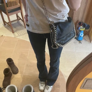 Tiamo väska - Säljer en svart tiamo💕 väska då jag inte använder den längre! Köpt för 350 kr💵 Hyfsat stor men ett fack på baksidan  och två fack på insidan ena har dragkedja💕 Kedjan har tappat lite färg på vissa ställen skriv för fler bilder! Pris kan diskuteras💕