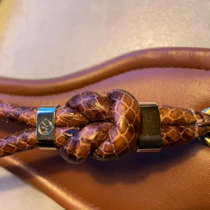 Michael Kors Sandaler  - Superläckra sandaler med flätade remmar och snygga detaljer från Michael Kors. Fler foton finns. 