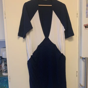 Klänning Rodebjer - Väldigt djupt urringad klänning med två fickor! Tillverkad i stretchig mjuk viskos som andas och är väldigt bekväm mot huden. Köpt för många år sedan på MQ och använd väldigt sparsamt, inga noppror eller så. 