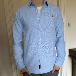 Ralph Lauren Skjorta - Ralph Lauren skjorta ”Oxford Slim” i nästintill nytt skick, 9.5/10. Nypris: 1599 kr. Storlek: L, passar L och M. 