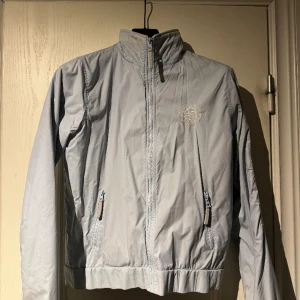 Tunn jacka - Säljer en snygg tunn vind jacka som är köpt second hand med tryck på där de står ”Athletic Sports 1995 Varsity” köpt för ungefär 1,5 år sedan men endast använd några gånger.