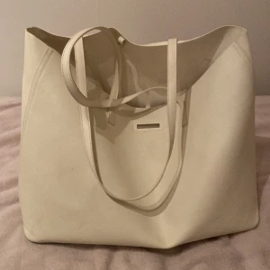 Axelväska HM - Axelväska från H&M, köpt förra året för runt 200-300kr. Den har tecken på användning, därför säljer jag den billigt. Bra till för jobbet eller skolan! Datorn får plats perfekt. 