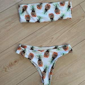 Bandeau-bikini med ananasmönster i storlek M. Halvstring-modell och hög midja. Från Boohoo. Mycket fint skick!