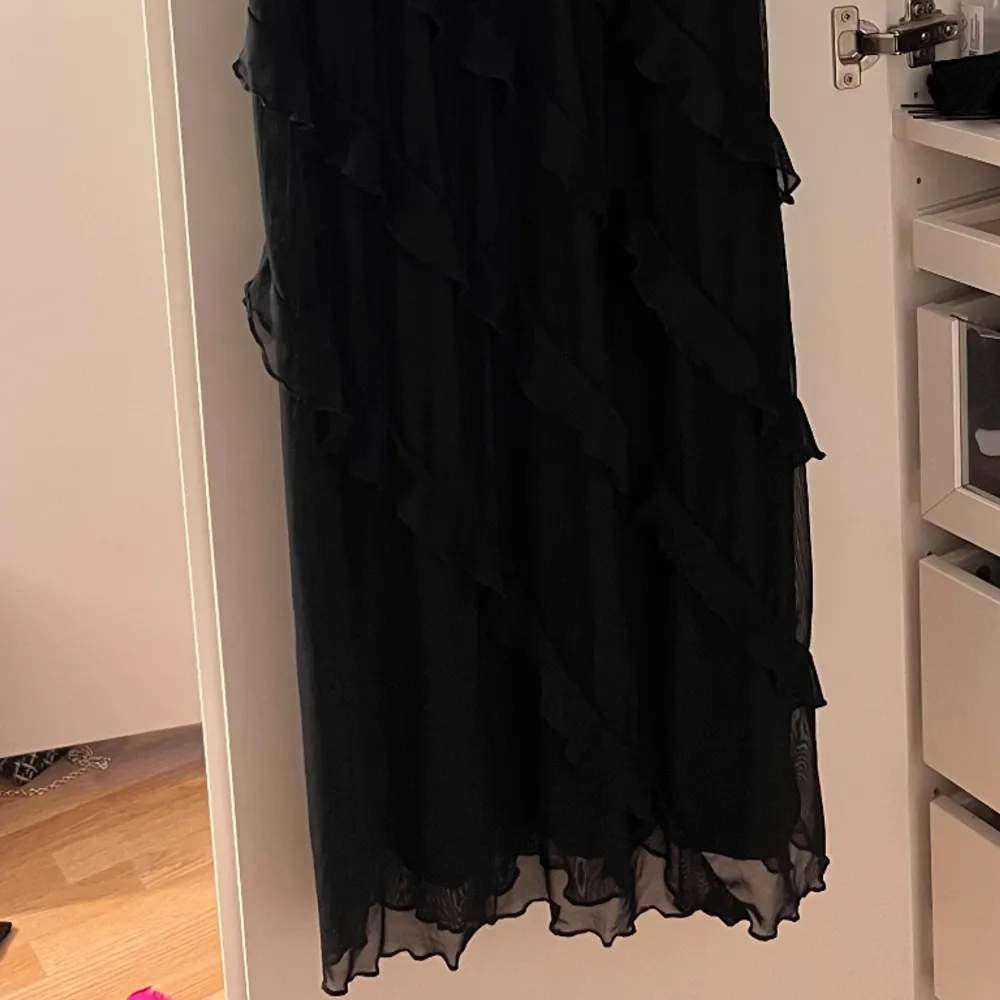 Säljer denna underbara volang klänning i svart. Denna klänning är helt oanvänd. Denna klänning har även en slits vid sidan. Klänningar.