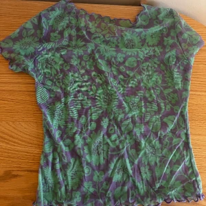 Gullig lila/grön topp - Säljer denna gulliga topp i ca storlek xs/s. Hittar ingen lapp då den borde vara borttagen. Lite genomskinlig. Använd få gånger. Inga skador. 