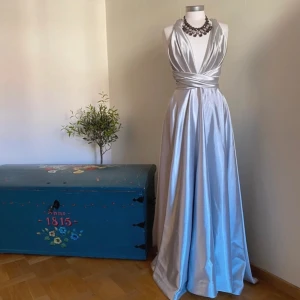 Balklänning  - Säljer denna snygga vit/ silvriga balklänning. Endast använd 1 gång. Omkrets i midjan är 76cm, längd från midjan är 110 cm