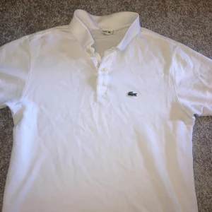 Lacoste vit piké - En vit pike/polotröja ifrån Lacoste, den är i fint skick och jag säljer den då jag växt ur den. Tröjan är storlek 164 vilket motsvarar ungefär XS, priset går att diskutera😁👍
