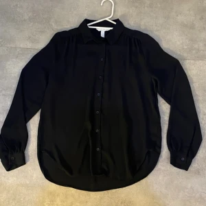 Skjorta- svart - Klassisk svart långärmad skjorta med svarta knappar från H&M. Använda endast en gång och är i nytt skick.