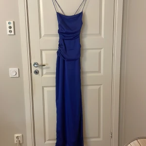 Klänning  - Säljer denna super fina balklänning som endast är använd en gång☺️klänningen är lång och har en superfin knytning i ryggen samt en slit på vänster ben🥰skriv privat för fler bilder
