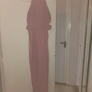 Oanvänd balklänning  - Balklänning oanvänd i storlek XS-S Ljusrosa i färgen med en dragkedja i ryggen, öppen i sidorna! 