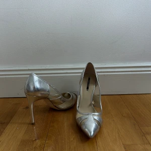Silvriga klackskor  - Spetsiga klackskor från Zara. Köpta från Sellpy men har aldrig använt pga för små. 