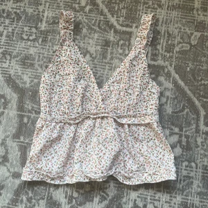 Volang topp blommig - Blommig topp med volanger som är perfekt inför sommaren❤️ Sitter som S-XS! Mycket fint skick och nästan aldrig använt den🥰