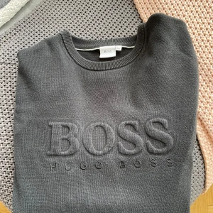 Hugo boss stickad tröja - Stickad Hugo Boss tröja med den äldre och snyggare modellen. Användt ungefär 5 gånger när jag var yngre men har växt ut den. Modellen är 184 cm och väger 70 kg