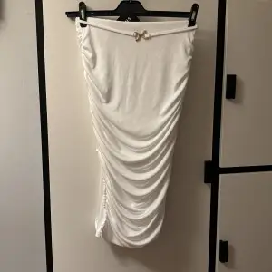 En väldigt snygg detaljerad vit kjol med slits på vänstra sidan. Med guld detalj vid framsidan! Om det önskas kan jag ta fler bilder privat och visa de hur det sitter på♥️♥️