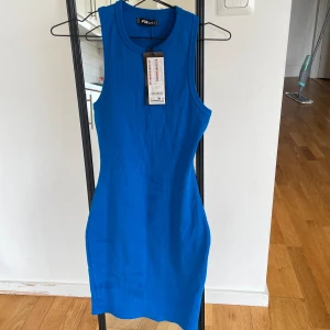 Klänning - Oanvänd klänning. Ger en fin figur. Liten i storlek. Jag har S/M och den passar bra.