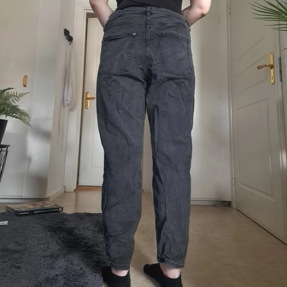 Mörkgrå/Svarta Mom Jeans i storlek 50 från H&M. Högmidjade och ankellånga. Använda ett fåtal gånger. Något skrynkliga men i mycket fint skick. . Jeans & Byxor.