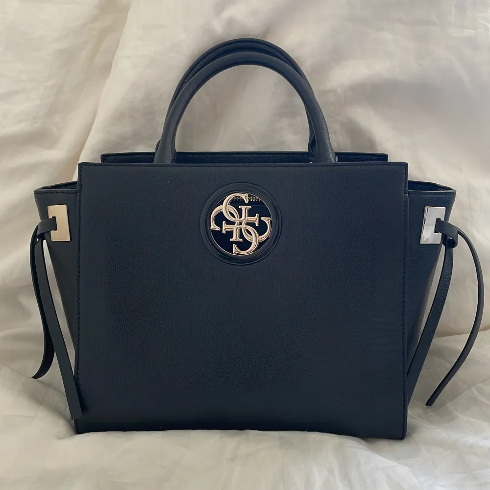Super snygg guess väska som är en svart handbag. Ordinarie pris 5000,har använd den två gånger💖. Väskor.