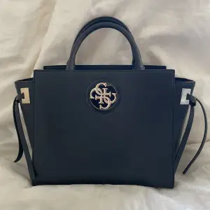 Super snygg guess väska som är en svart handbag. Ordinarie pris 3200,har använd den två gånger💖