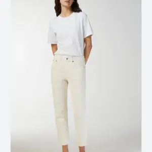 Strl: 27   Från hemsidan:   Classic five-pocket jeans with straight and slightly cropped legs, sewn from a denim twill made of organic cotton. The natural shade of raw cotton is carefully bleached and tinted to produce a warm ecru tone.  