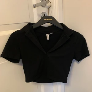 Svart topp från HM - Säljer denna svarta urringade toppen från h&m då den ej används ☺️ den har krage och är som i nyskick! 