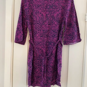 Svart och lila mönstrad klänning från Banana Republic i strl s i viskos i nyskick  - Endast använd en gång och är i väldigt fint skick.  Mått Över bröstet: ca 48 cm Längd från axeln och ner: ca 80 cm  Kommer från ett djur och rökfritt hem. 