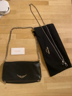 Zadig voltaire  - Köpt på NK för 3800 kr. Inget slitage på väskan, då jag inte använt den mycket. väskan är 27 cm bred. 