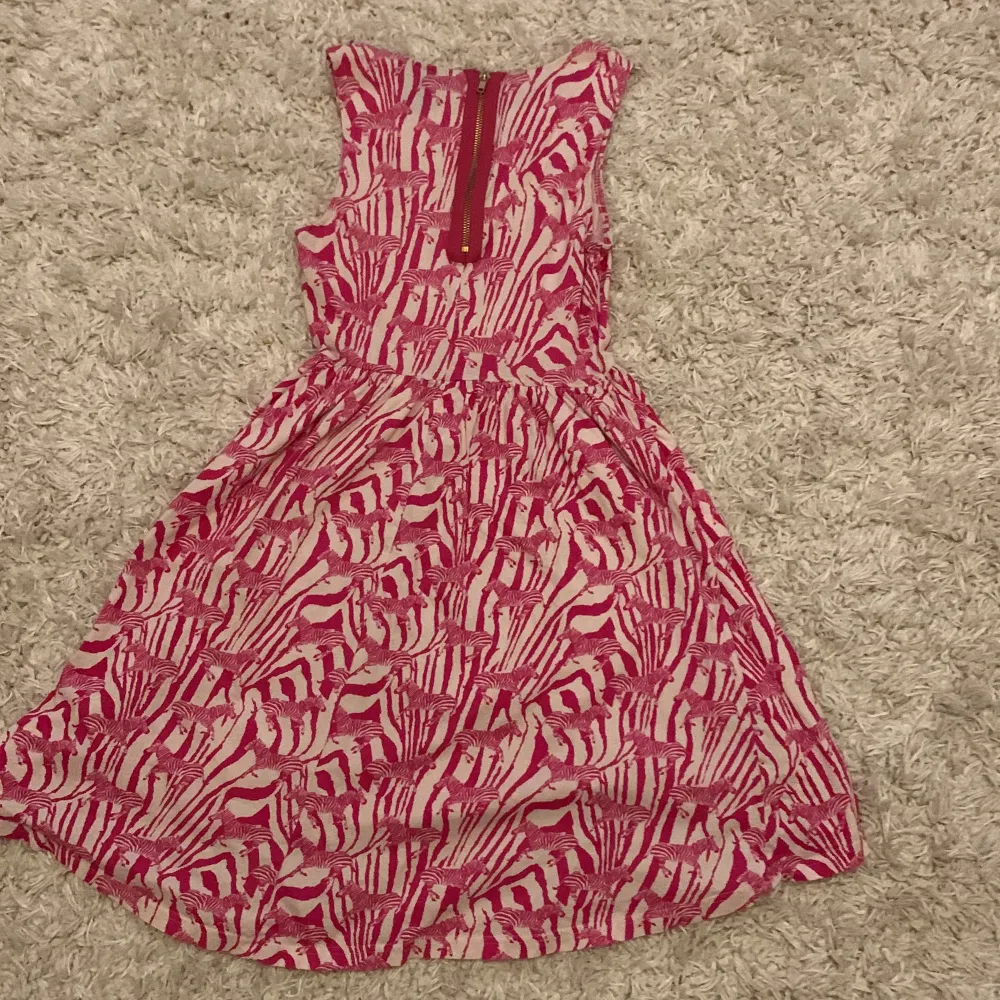 Säljer en rosa vit klänning med zebra mönster och zebror på i storlek XS.  Köpt på H&M och har bara varit använd 3 gånger av mig men är ärvd av en släkting. Klänningar.