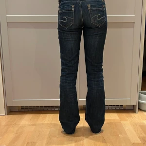 Lågmidjade jeans - Raka mörkblå jeans från Cross. Uppsprätta längst ned då de var korta men förövrigt bra skick. Skriv privat för mått eller fler bilder!