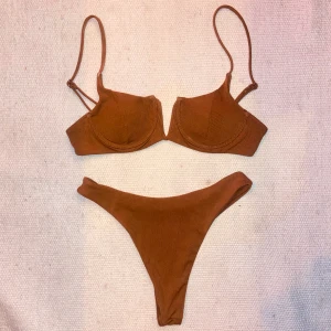 Brun ribbad bikini  - Bikini i ribbat tyg. Knappt använd! Vadderade kupor och högmidjade trosor. 